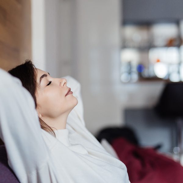 charming model is dreaming on sofa at home after classes