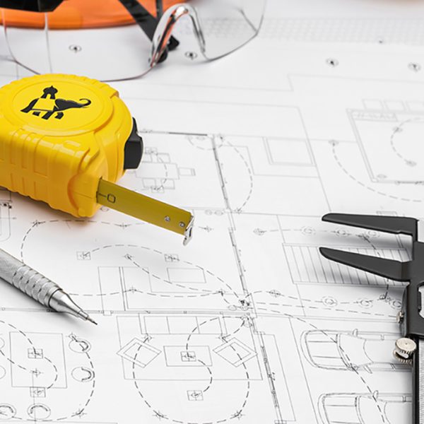 Construction plans with helmet and drawing tools on blueprints
