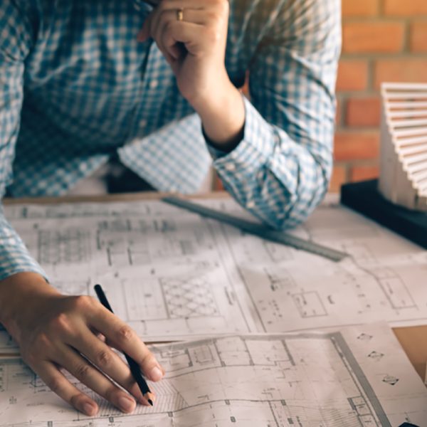 Construction plans with helmet and drawing tools on blueprints